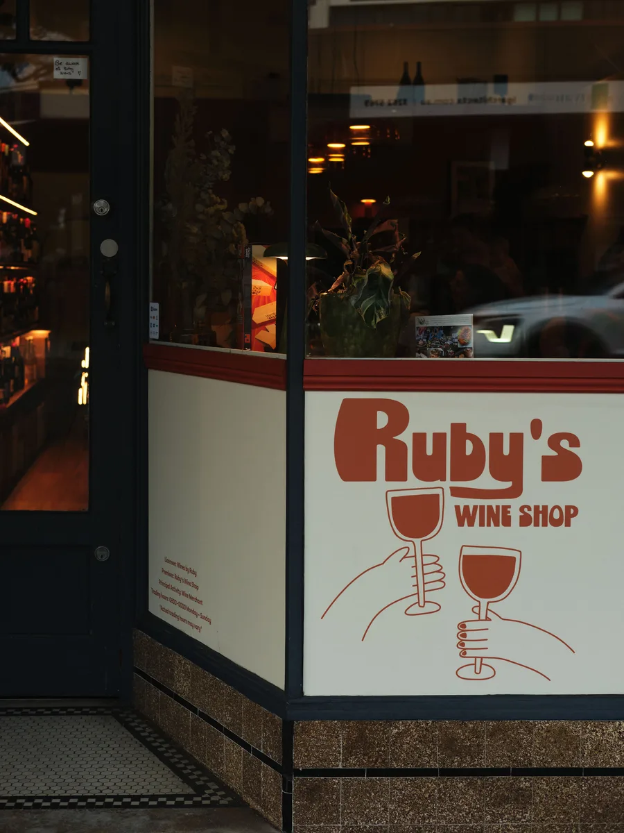 Ruby's Wine Shop storefront with logo and warm interior lighting